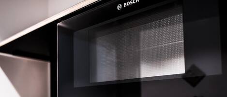 Un horno microondas Bosch con pantalla digital, botones de control y un temporizador configurado a las 16:08.