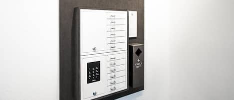 A modern elevator with a keypad and a "CHECK OUT" button, mounted on a wall with a logo and the text "TOWN LIVING".