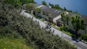A lakeside property with multiple buildings, a clear view of a lake, and a mountain in the background. - Loch Rannoch Highland Club (Pitlochry)