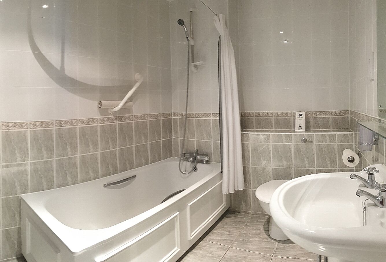 Een badkamer met een bad, douche en wastafel.