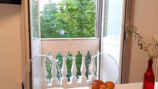 A dining table with a variety of food items, including fruits and pastries, and a vase with a plant. - B&B Lei (Foggia)