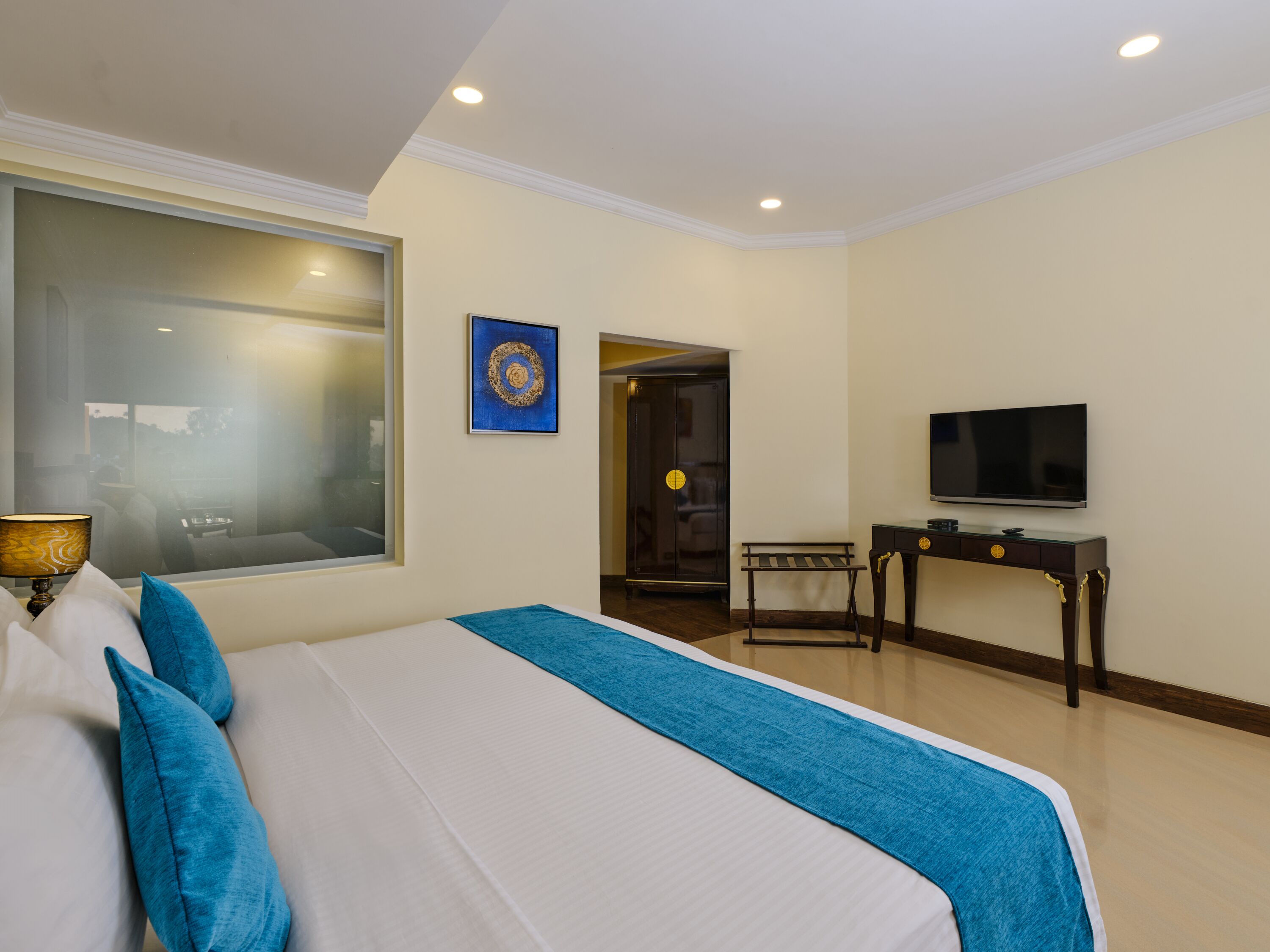Una camera d'albergo con un letto grande, una televisione, una scrivania e una finestra.