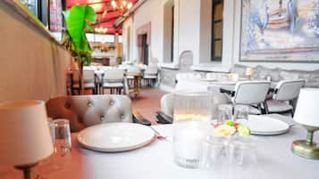 Enjoy a romantic dinner for two at this inviting dining area, complete with a beautifully set table and vibrant artwork.
