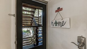 A door with a keypad lock, a 'No Smoking' sign, and a 'Home' sign on the wall.