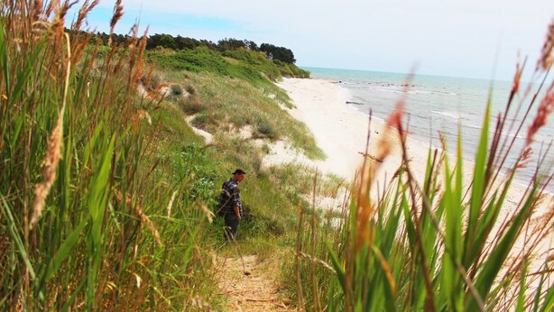 A pathway leading to a beach with a person walking. - Holiday home Aakirkeby (Akirkeby)
