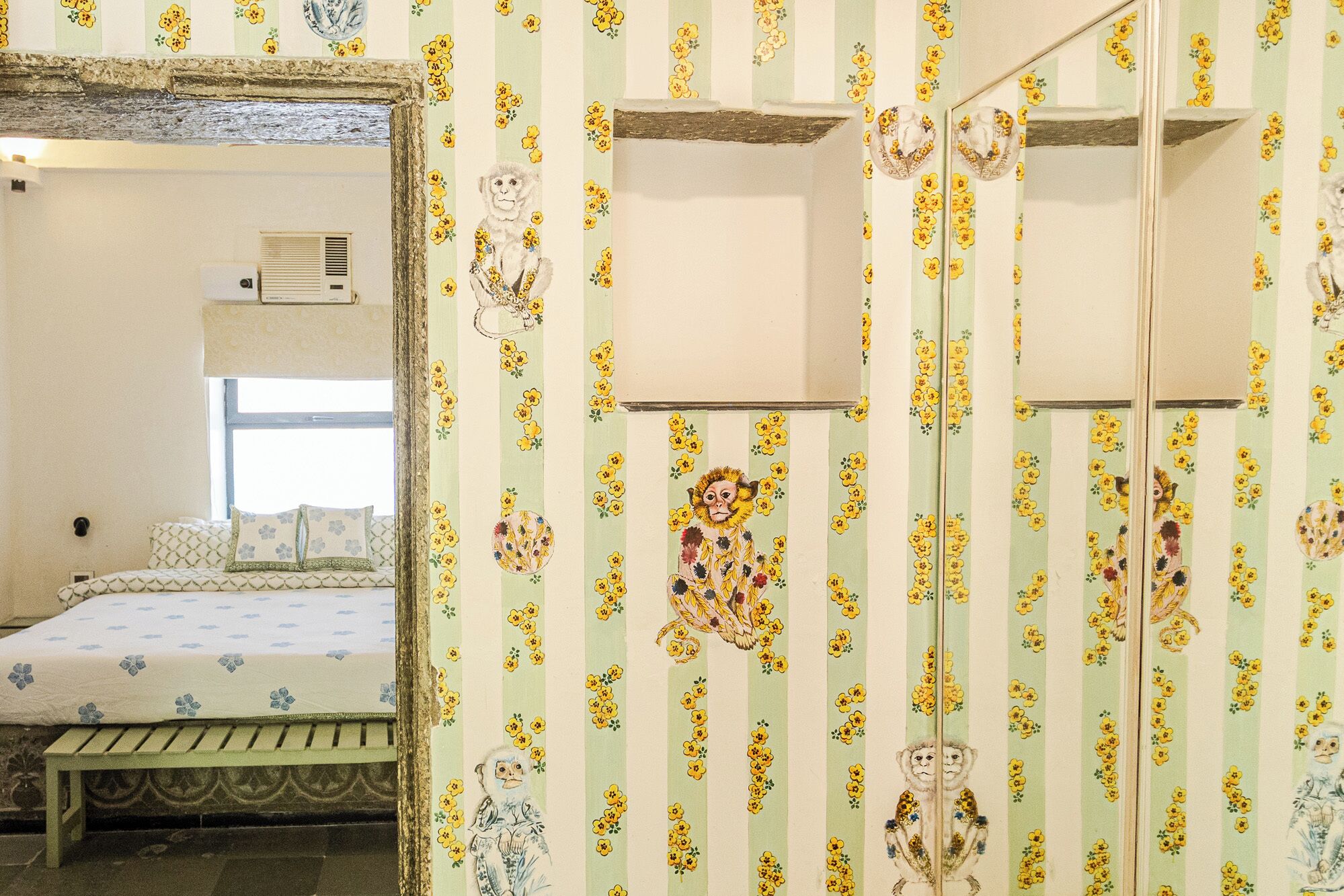 A room with a bed, a window, and a mirror.