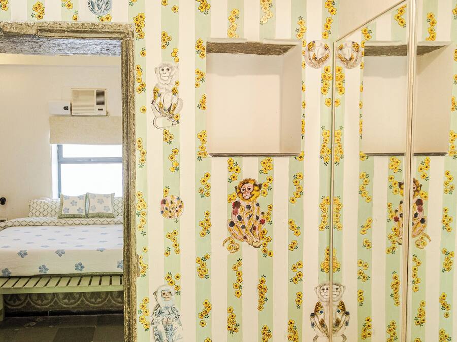 Ein Zimmer mit Bett, Fenster und Spiegel.