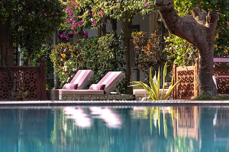 Alberca al aire libre, sombrillas en la alberca y camastros