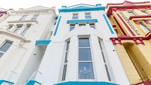 A multi-story building with a white facade and blue trim. - Five Way Apartments (Paignton)