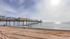A pier extending into calm waters with a clear sky. - Five Way Apartments (Paignton)