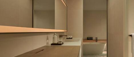 Een moderne badkamer met een grote spiegel, een badkuip en een zitbankje.