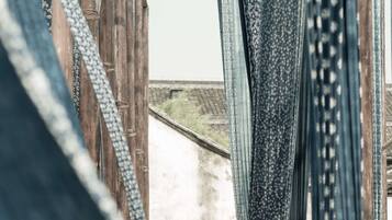 A person walking through a corridor lined with hanging fabrics.