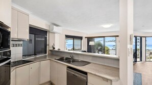 A modern kitchen with a view of the ocean, a dishwasher, and a sink. - Unit 4 'The Rocks', Coolum Beach (Coolum Beach)
