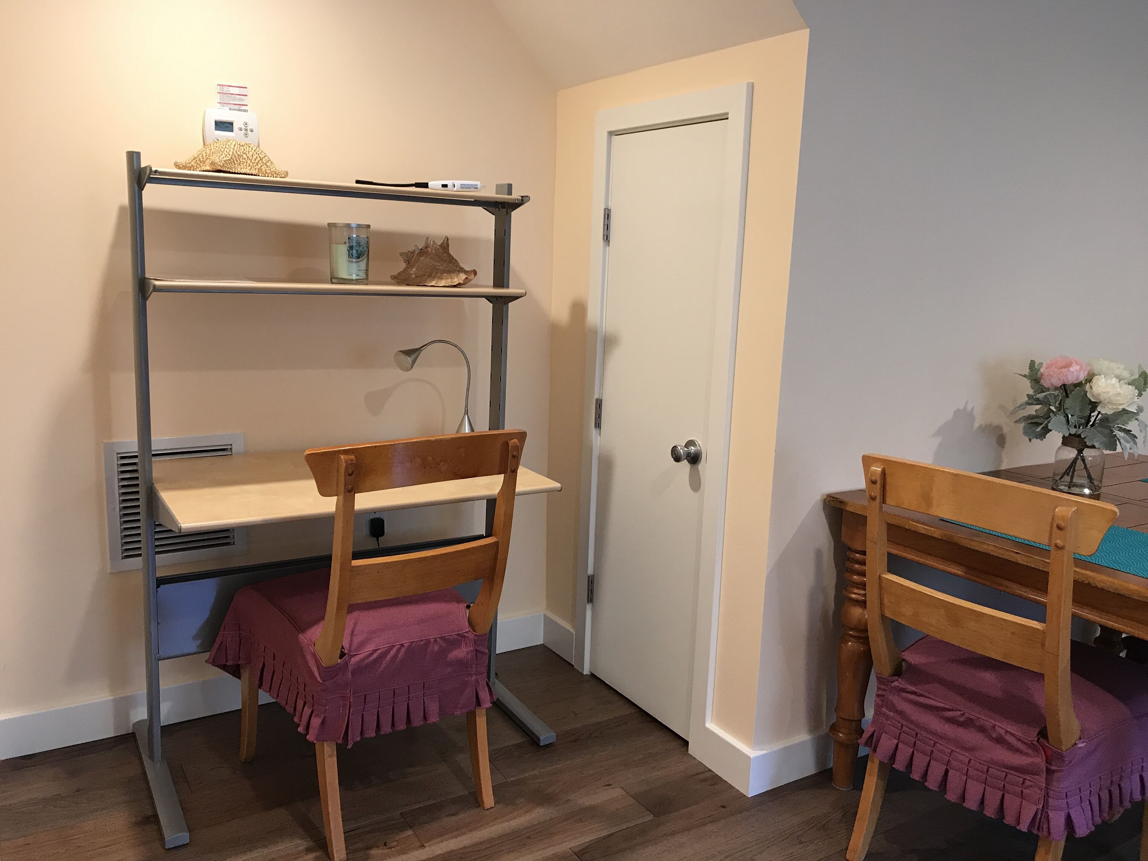 A study area with a desk, chair, and shelving unit.
