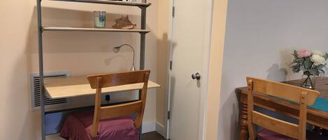 A study area with a desk, chair, and shelving unit.