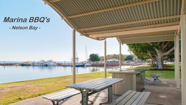 A marina with a covered seating area, a picnic table, and a bench.