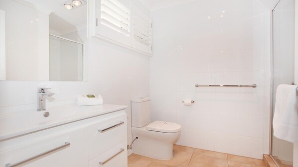 A modern bathroom with a white vanity, a toilet, and a shower area. - 11 Dalmor Court (Coolum Beach)