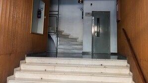 A staircase leading to a door with a blue ceiling and wooden walls. - Garden Central Athinian Apartments (Athens)
