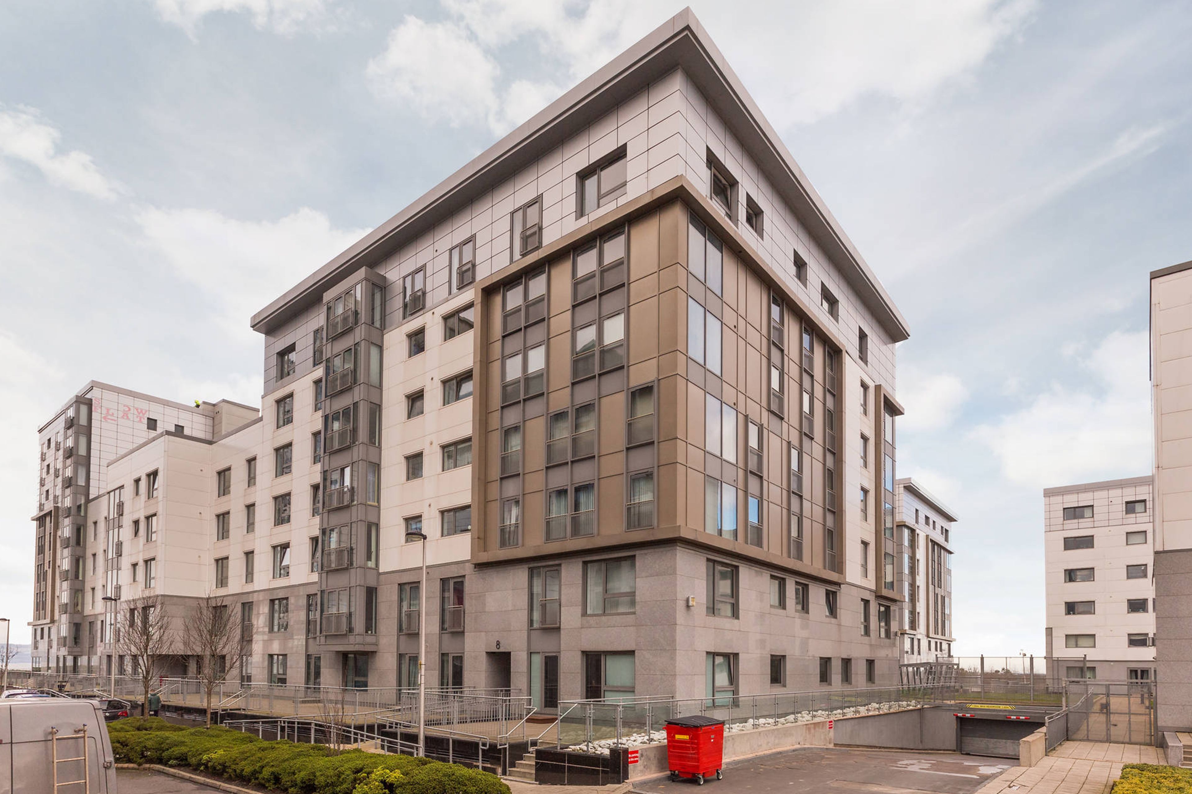 A modern multi-story building with a flat roof, large windows, and a clean, contemporary design.