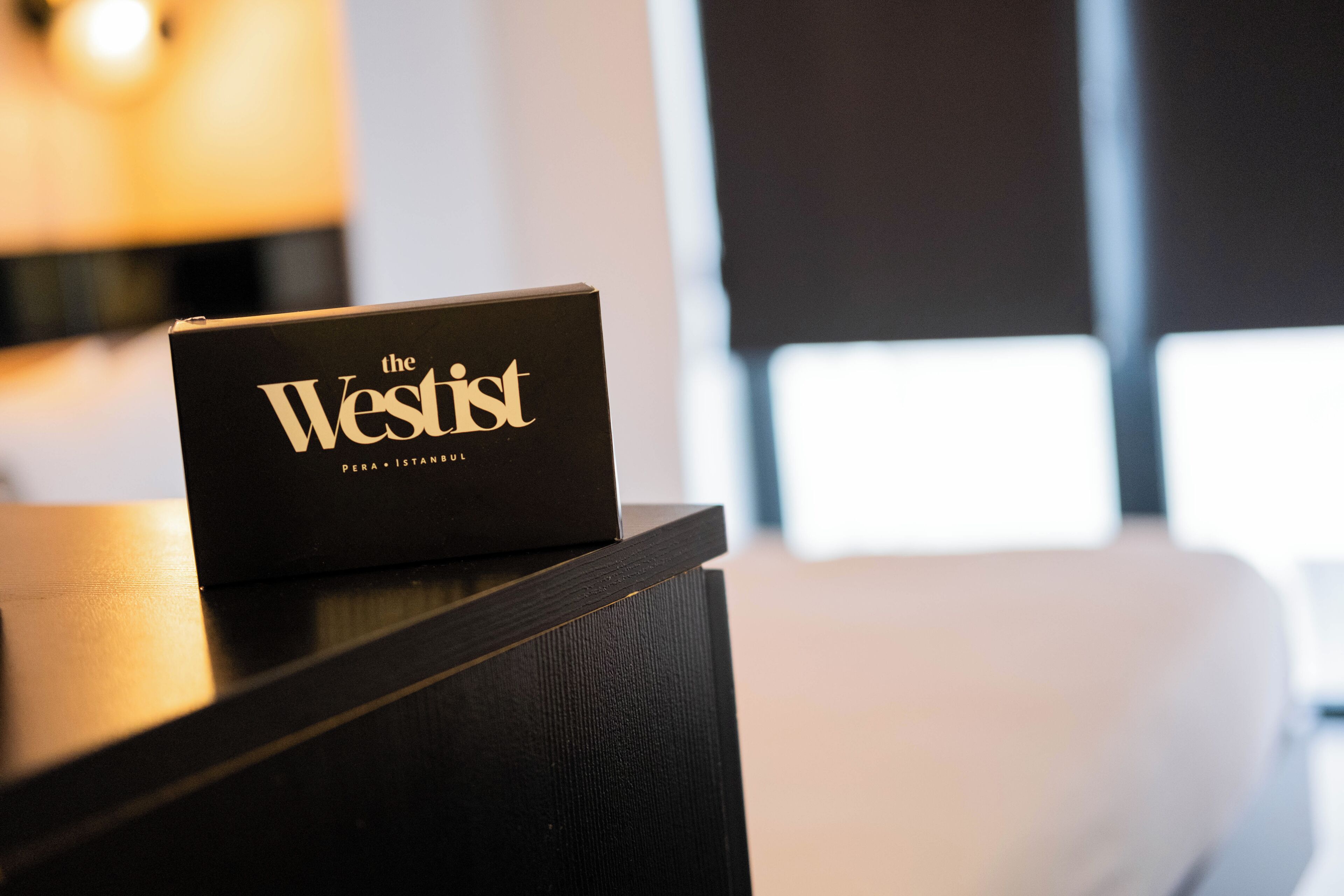Un letrero negro con letras doradas sobre una superficie de madera, probablemente indicando el nombre de un hotel.