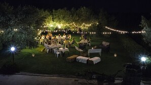 An outdoor dining area with tables and chairs, surrounded by trees and string lights. - Zà Culetta (Rocca San Giovanni)