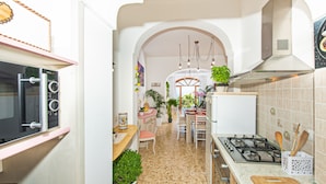 A kitchen with a gas stove, microwave, and various plants. - Positano Villa Genny and Emily breakfast & experience (Positano,Montepertuso)