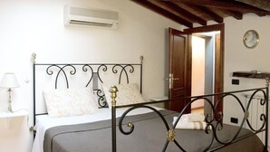 Une chambre à coucher avec un lit, une lampe de chevet, un appareil de climatisation et un plafond en bois.