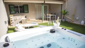 A hot tub with a control panel, surrounded by outdoor furniture and a dining area with a table and chairs. - Luxury Villa in Maspalomas, Jacuzzi, Wifi, Pool, Parking (Maspalomas)