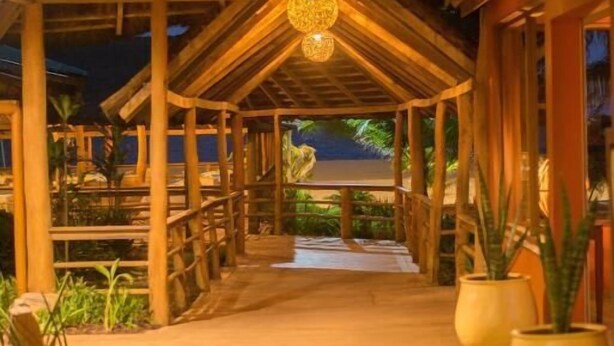 A wooden covered walkway with a ceiling structure and a hanging light fixture. - Casa Del Papa Resort & SPA (Ouidah)