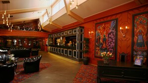 A lobby with leather seating, a reception desk, and a large mural. - Storefjell Resort Hotel (Gol)