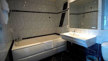 Ein modernes Badezimmer mit einer Badewanne, einem Waschbecken und einer Toilette.