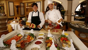 A buffet setup with various food items and a chef preparing food. - Storefjell Resort Hotel (Gol)