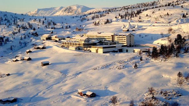 A snow-covered mountain resort with multiple buildings, including a large hotel with multiple floors and a ski lift visible in the background. - Storefjell Resort Hotel (Gol)
