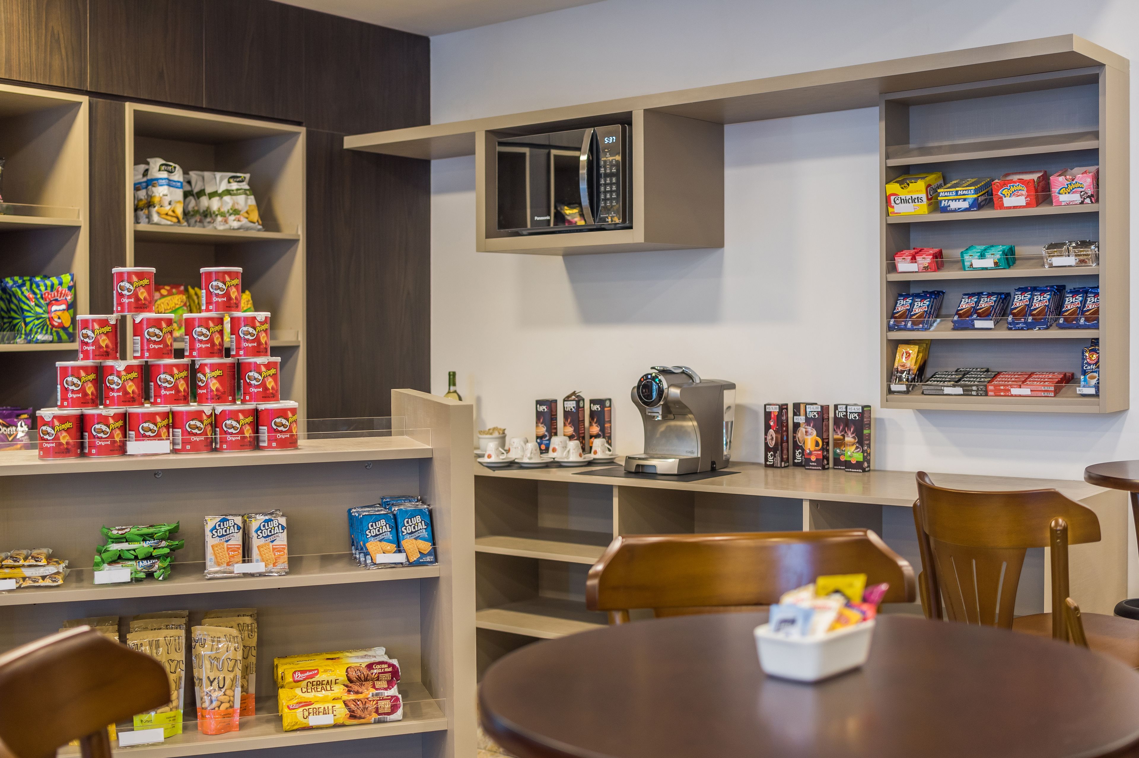 Un desayunador con estantes llenos de cereales, café y aperitivos.