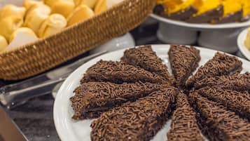 Un bufé con diversos postres, incluyendo dulces cubiertos de chocolate y pastelería.