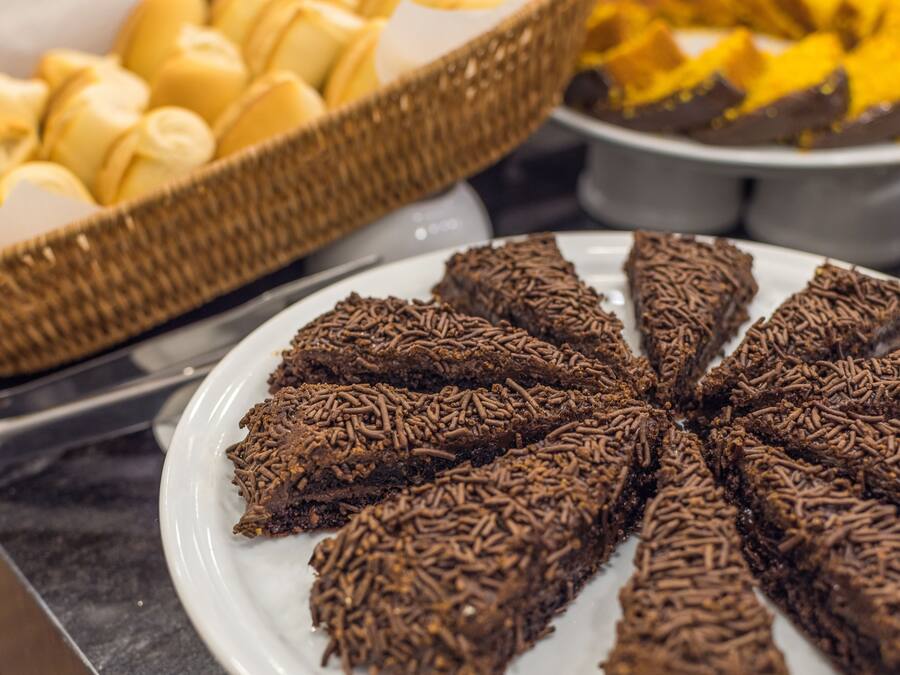 Un bufé con diversos postres, incluyendo dulces cubiertos de chocolate y pastelería.