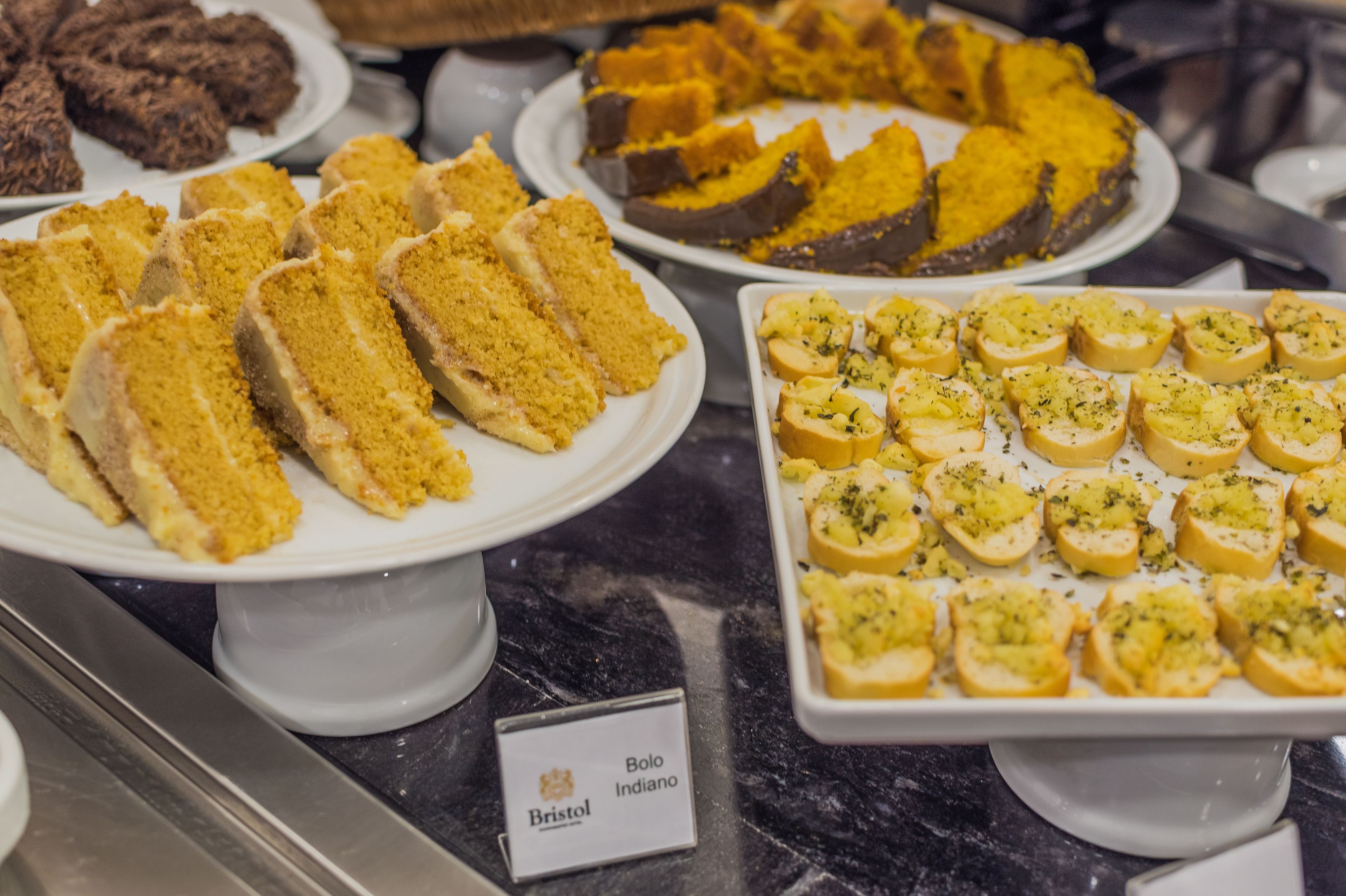 Un bufé con diversos postres, incluyendo pasteles y pan.