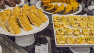 Un bufé con diversos postres, incluyendo pasteles y pan.
