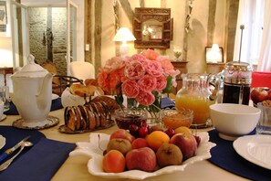 A breakfast setting with a variety of fruits, pastries, and beverages on a table. - Ombre Rose (Le Fousseret)