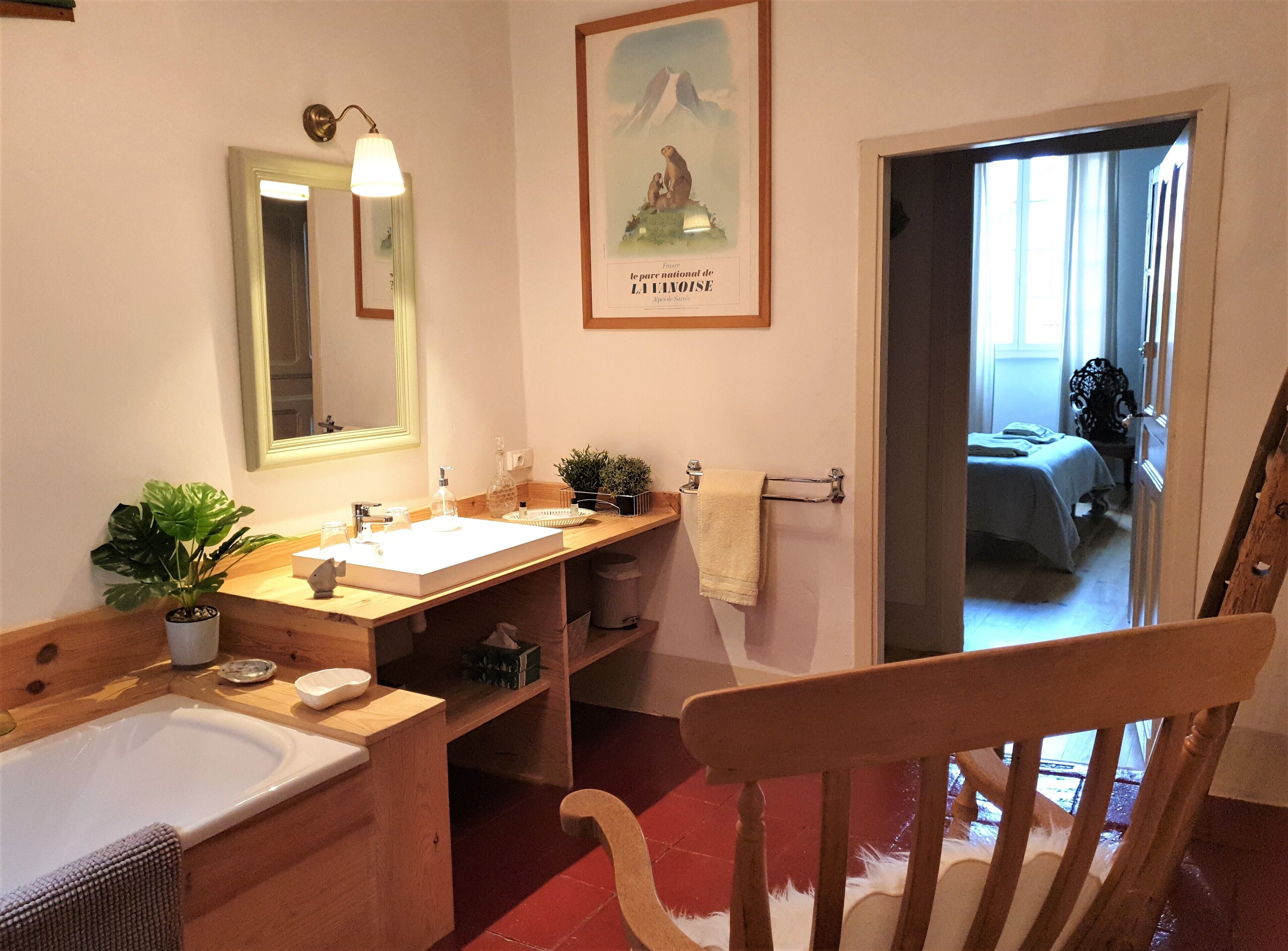 A bathroom with a wooden vanity, a sink, a mirror, and a towel rack.