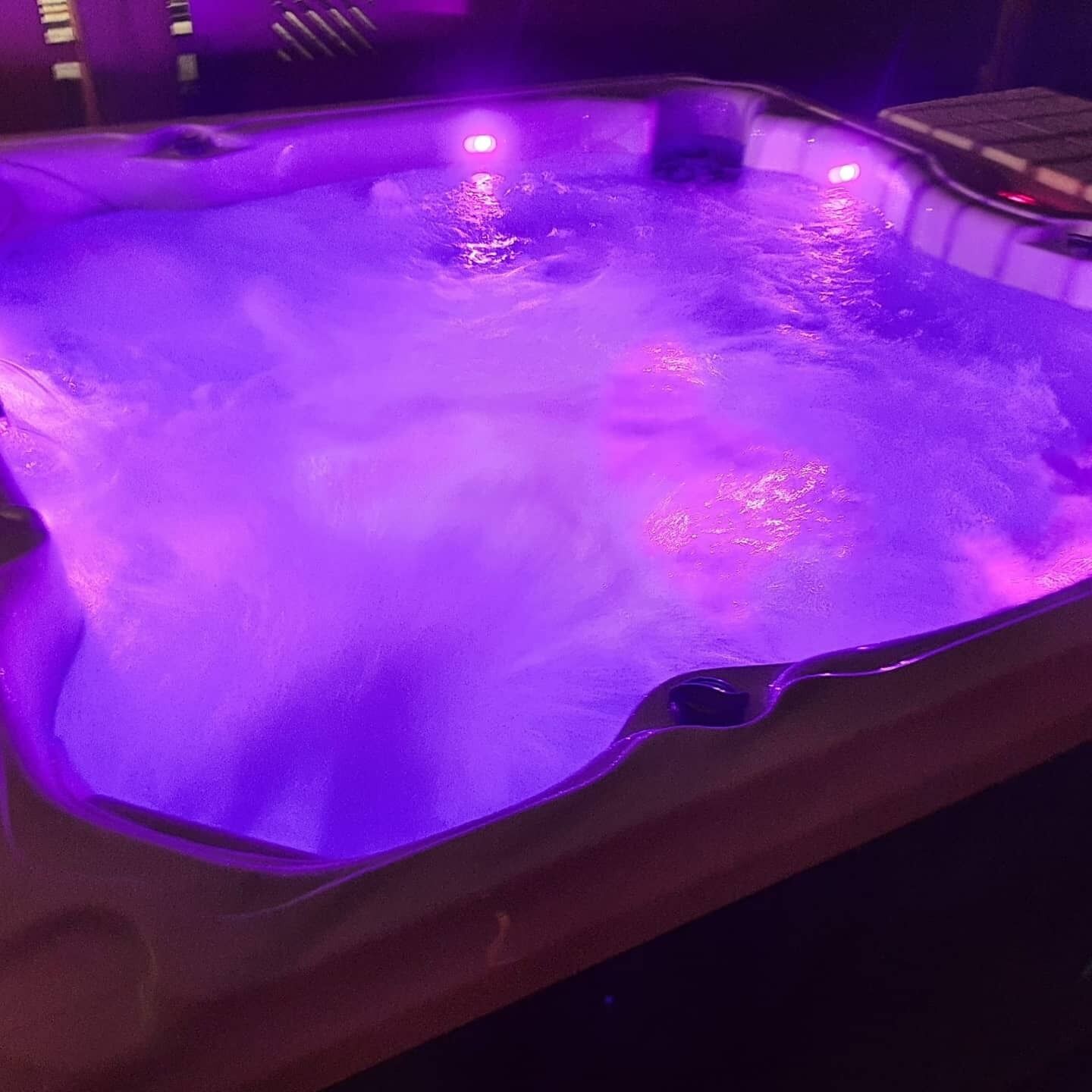 A hot tub with purple lighting.