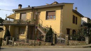 A two-story building with a balcony, a staircase, and a gated entrance. - Chiantirooms Guesthouse (Greve in Chianti)