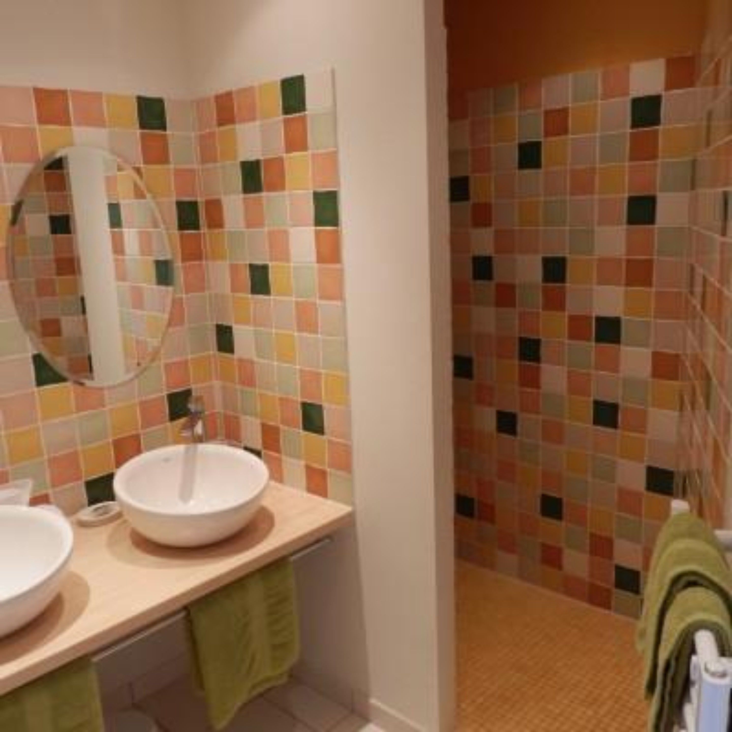 Een badkamer met een wit wastafel, een spiegel en een betegelde muur met een ruitpatroon.