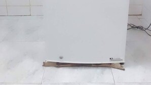 Un réfrigérateur LG blanc se trouve dans une pièce dont les murs et le sol sont recouverts de carreaux blancs.