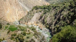 A mountainous landscape with a river flowing through a valley. - Colibrí Lodge (Tapay)