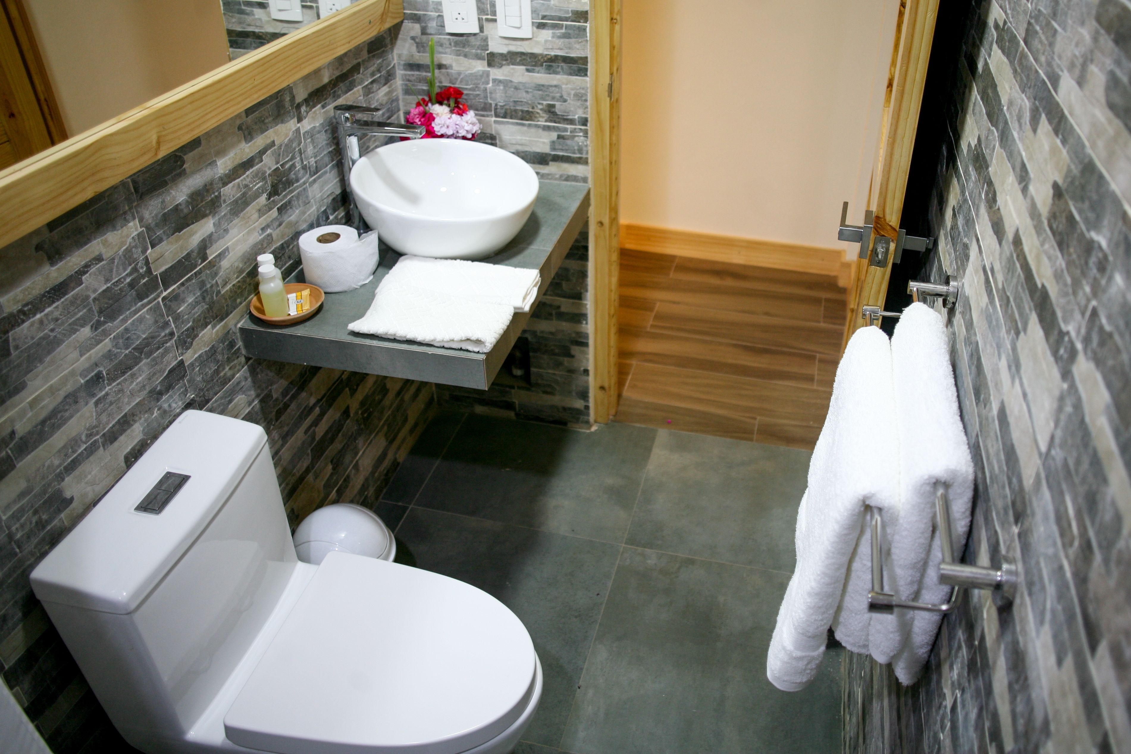 Une salle de bain équipée de toilettes, d’un lavabo et d’un porte-serviettes.