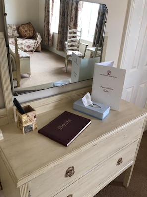 A hotel room with a wooden dresser, a mirror, a presentation folder, a book, and a tissue box. - Brewers Arms (Goole)