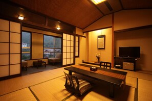 A traditional Japanese-style room with tatami flooring, a low table, and sliding doors. - Unzen Fukudaya (Unzen)