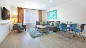 Een moderne woonkamer met een bank, salontafel en eethoek.