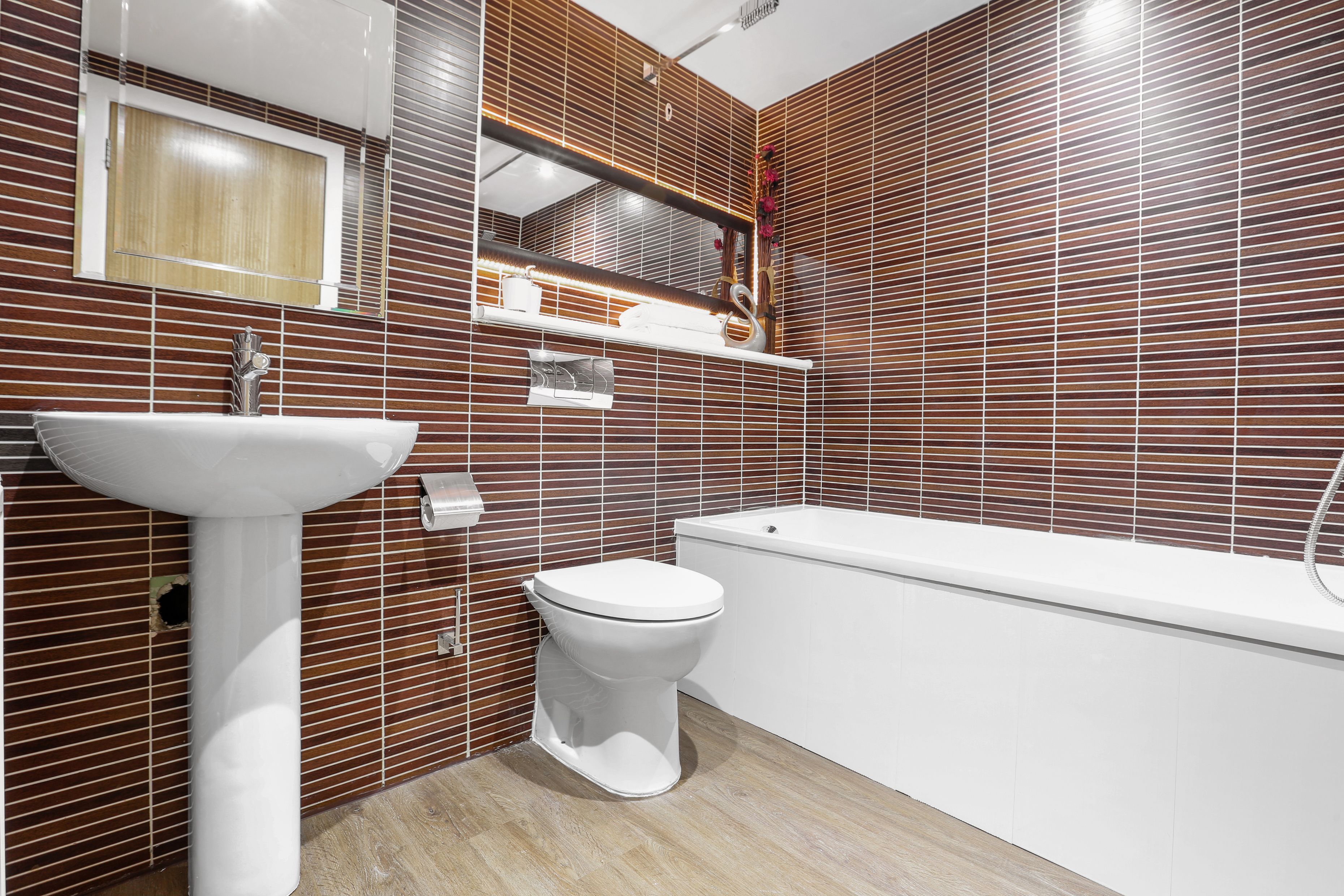 A modern bathroom with a white sink, toilet, and bathtub.